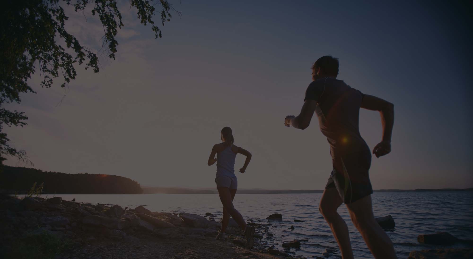 couple jogging into sunrise